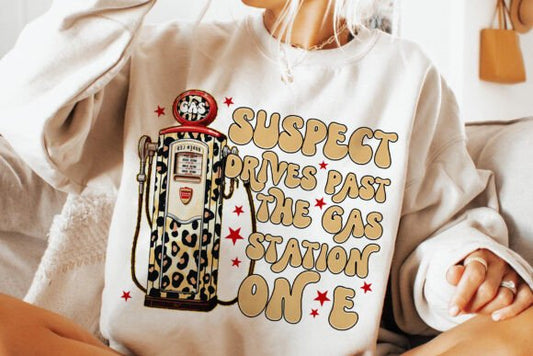 Suspect drives past the gas station on E leopard SHIRT